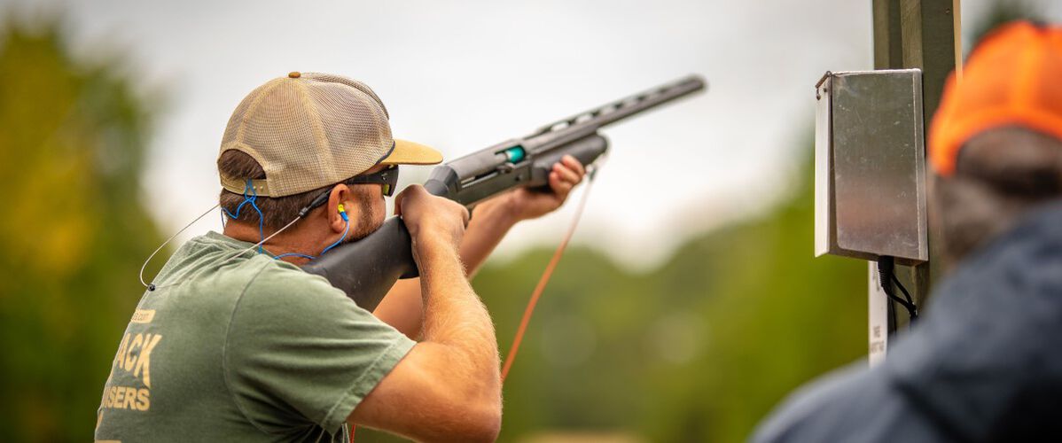 shooter aiming shotgun outside